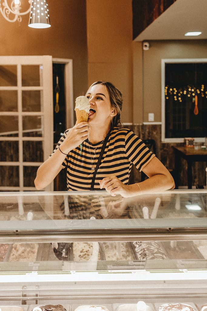 Woman Wearing Striped Shirt Holding Ice Cream enjoying summer